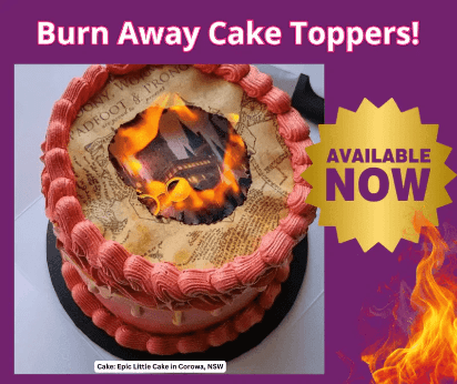 Cake with text 'Burn Away Cake Toppers!' and 'Available Now' on a purple background